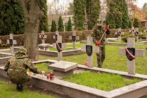 Funkcjonariusze NOSG porządkują groby poległych żołnierzy