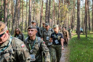 Uczestnicy rajdu pieszego maszerują przez tereny leśne