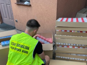 Funkcjonariusz Straży Granicznej zabezpieczający nielegalne papierosy