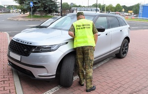 Funkcjonariusz SG prowadzi kontrole graniczną pojazdu przekraczającego granicę w Terespolu
