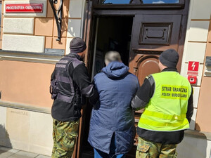 Funkcjonariusze prowadzą poszukiwanego obywatela