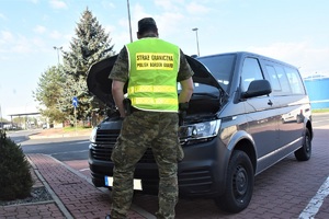 Funkcjonariusz prowadzi kontrolę graniczną pojazdu na terenie drogowego przejścia granicznego w Terespolu