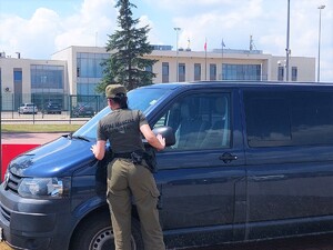 Funkcjonariuszka SG podczas czynności kontrolnych pojazdu realizowanych na terenie drogowego przejścia granicznego w Zosinie