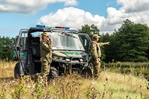 Funkcjonariusze SG podczas patrolu granicznego przy pojeździe terenowym