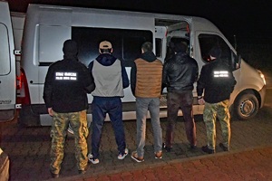 Funkcjonariusze SG podczas doprowadzenia osób zatrzymanych