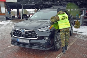 Funkcjonariusz SG prowadzi kontrolę pojazdu na terenie drogowego przejścia granicznego w Terespolu