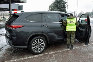 Funkcjonariusz SG prowadzi kontrolę pojazdu na terenie drogowego przejścia granicznego w Terespolu