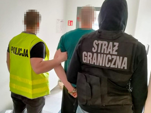 Funkcjonariusze podczas doprowadzenia osoby podejrzanej